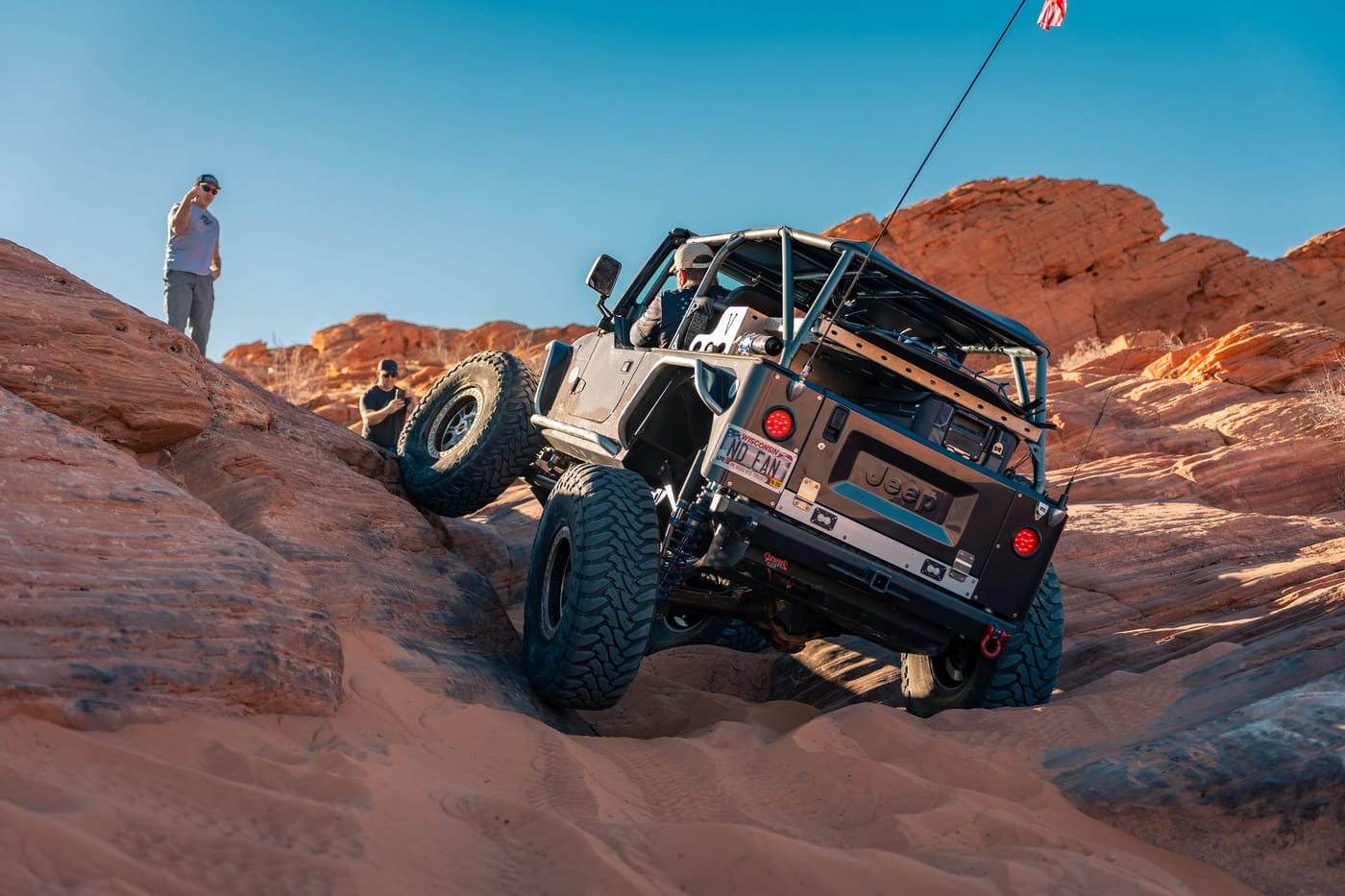 Jeep navigating near-vertical rock face at Sand Hollow